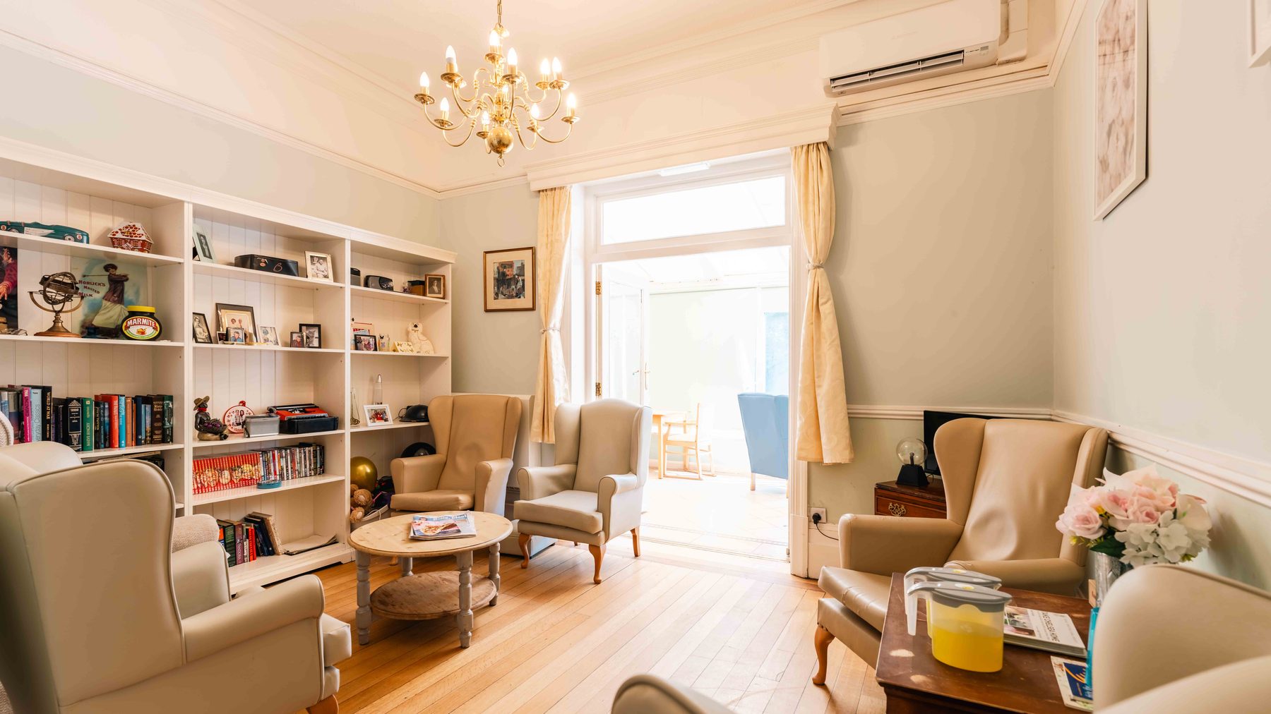 A carer supporting a resident in a comfortable lounge at Wraysbury House