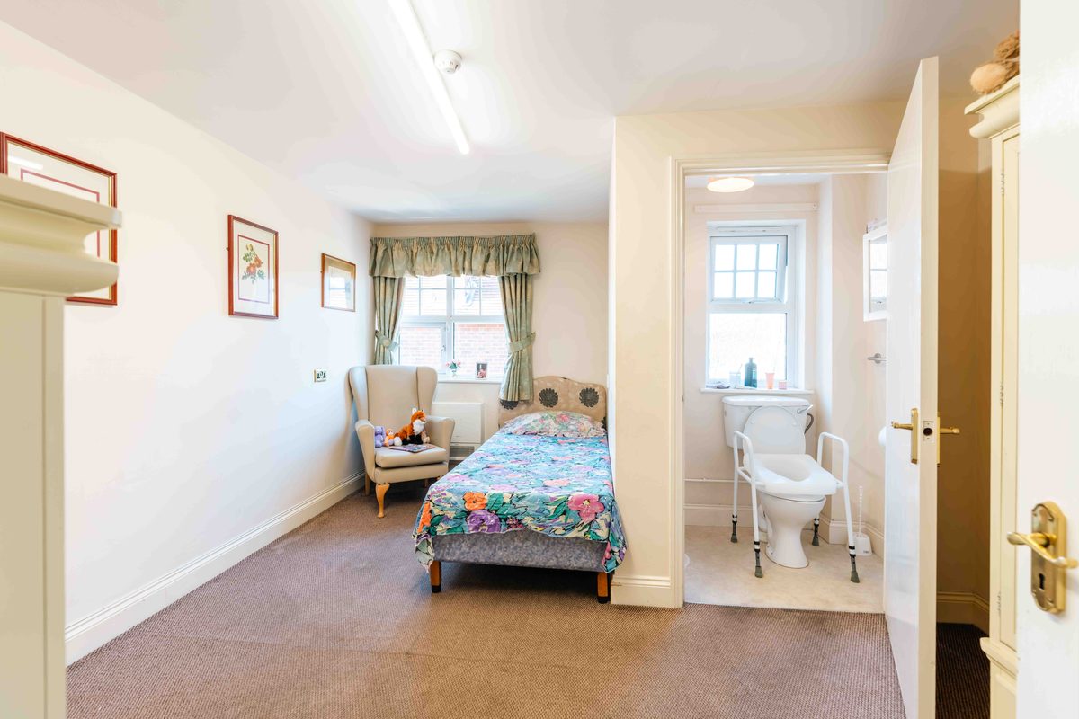 A bedroom with an armchair by the window